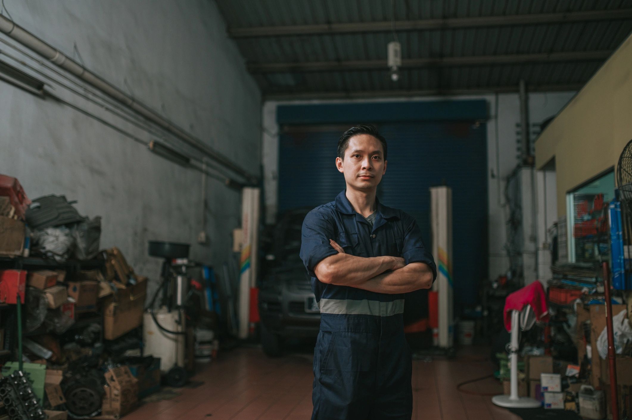 Auto technician portrait in front of a repair shop