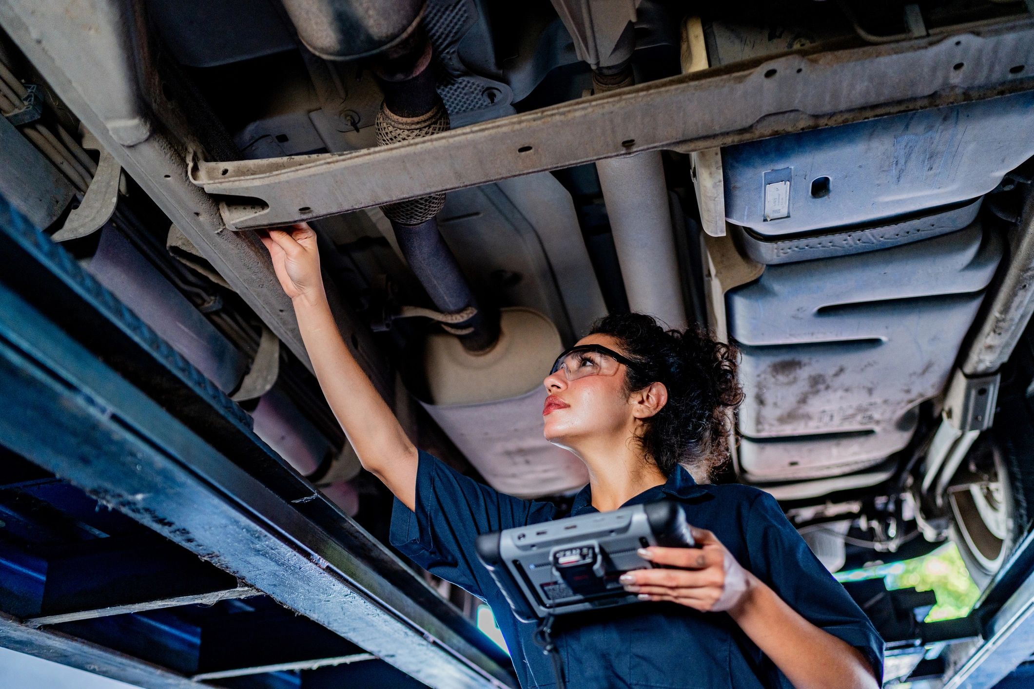 Technician inspecting a vehicle in a repair bay
