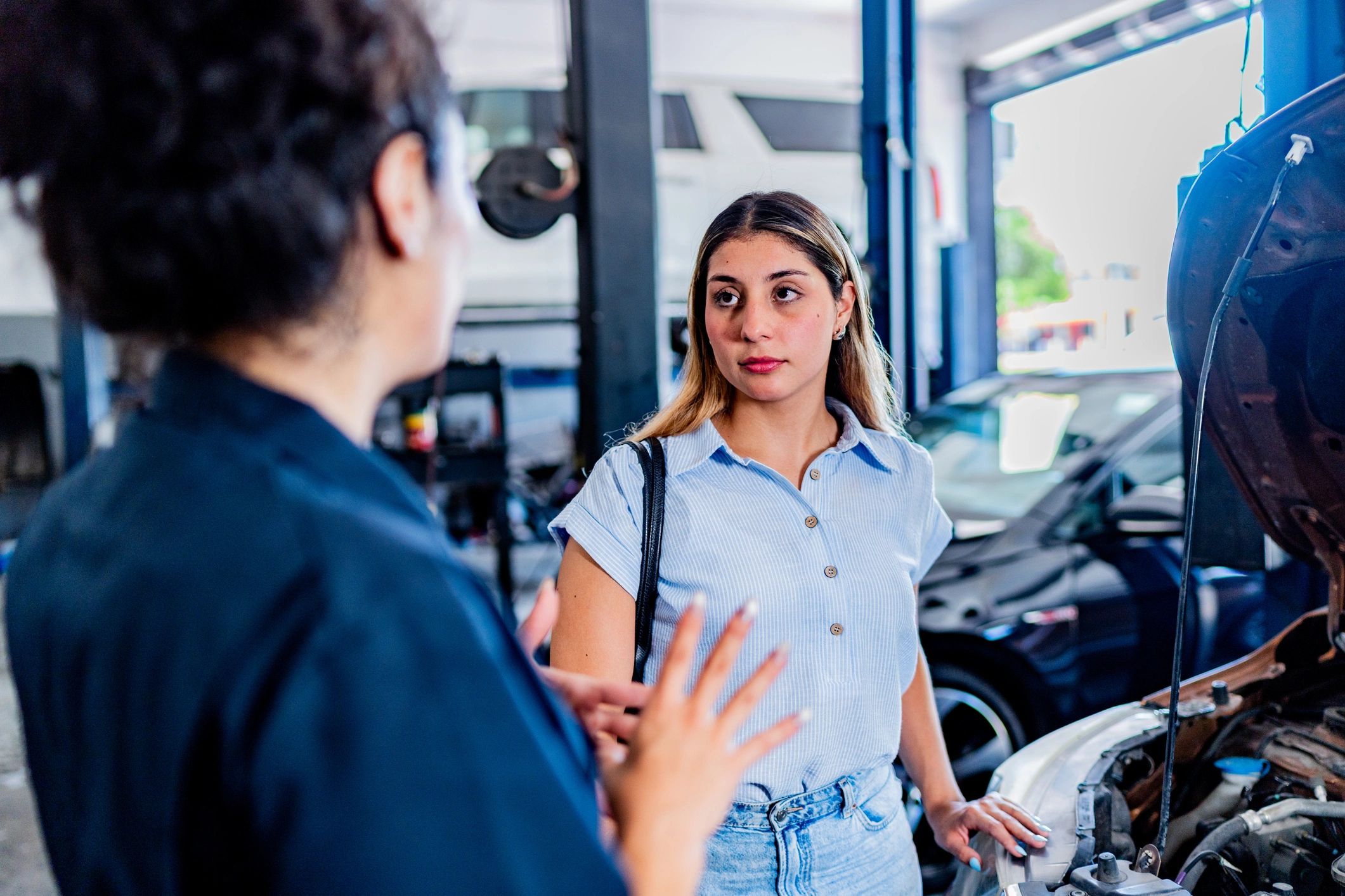 Customer speaking with a mechanic at an auto repair shop